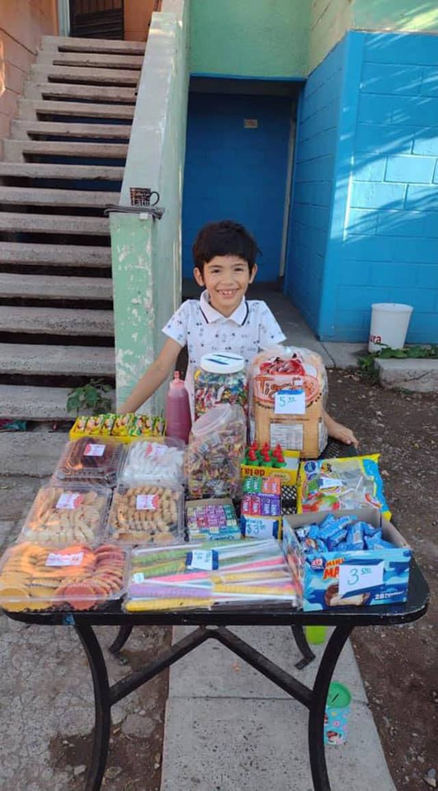 Niño vende dulces afuera de su casa para poyar a sus papás con los gastos del regreso a clases.