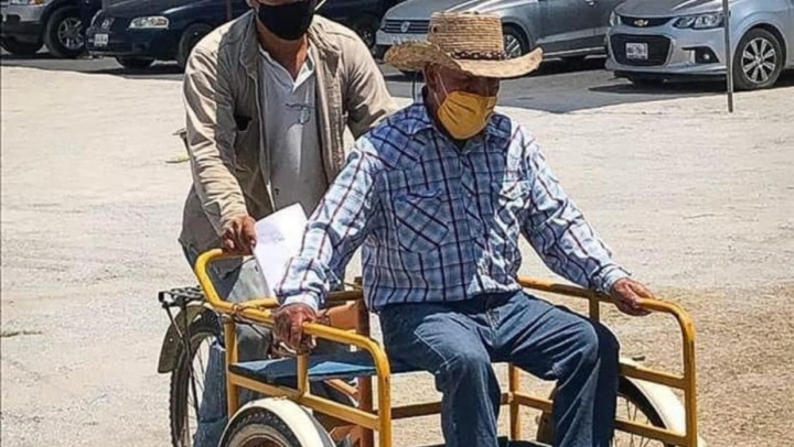 Abuelito llega en triciclo para recibir su vacuna COVID.