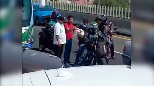 Motociclista rescata a bebé atrapada en bloqueo vehicular en Ecatepec