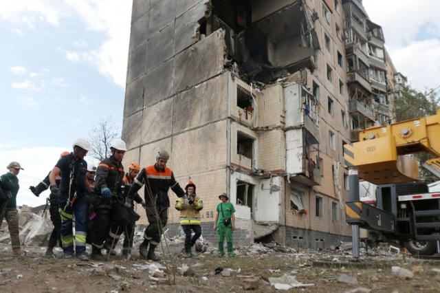 Un grupo de rescatistas traslada el cuerpo recuperado de un residente de uno de los edificios de nueve pisos que fue parcialmente destruido debido al ataque ruso con misiles en Krivói Rog, en Ucrania, el 31 de julio de 2023. 