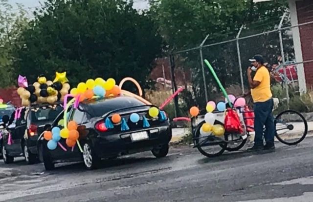Papá adorna triciclo para la caravana de graduación de sus hijos.