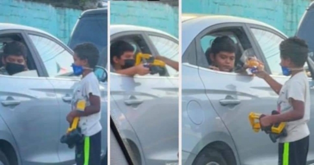 Niño le regala su juguete a otro que limpia parabrisas.